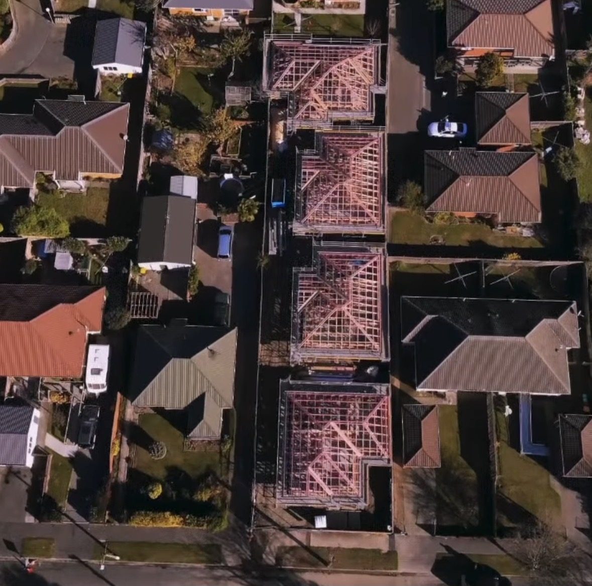 Aerial view of four townhouses at framing stage