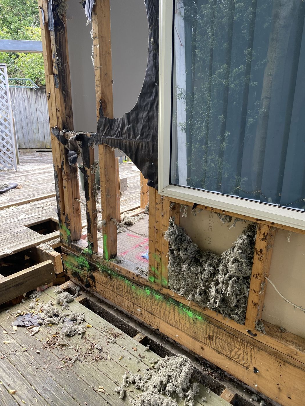 Water-damaged framing exposed beneath a window