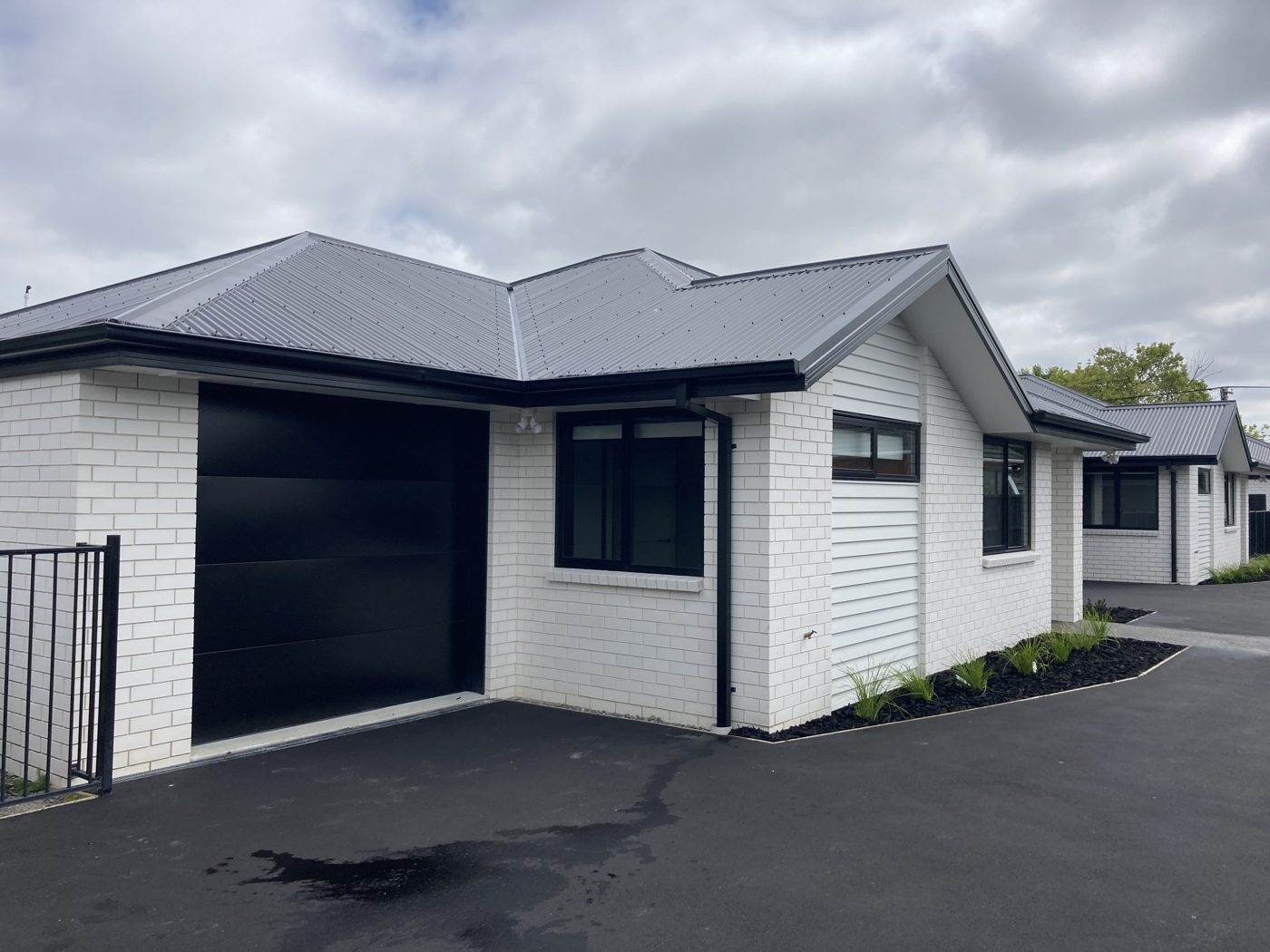 Completed townhouses with white brick, weatherboard and black joinery