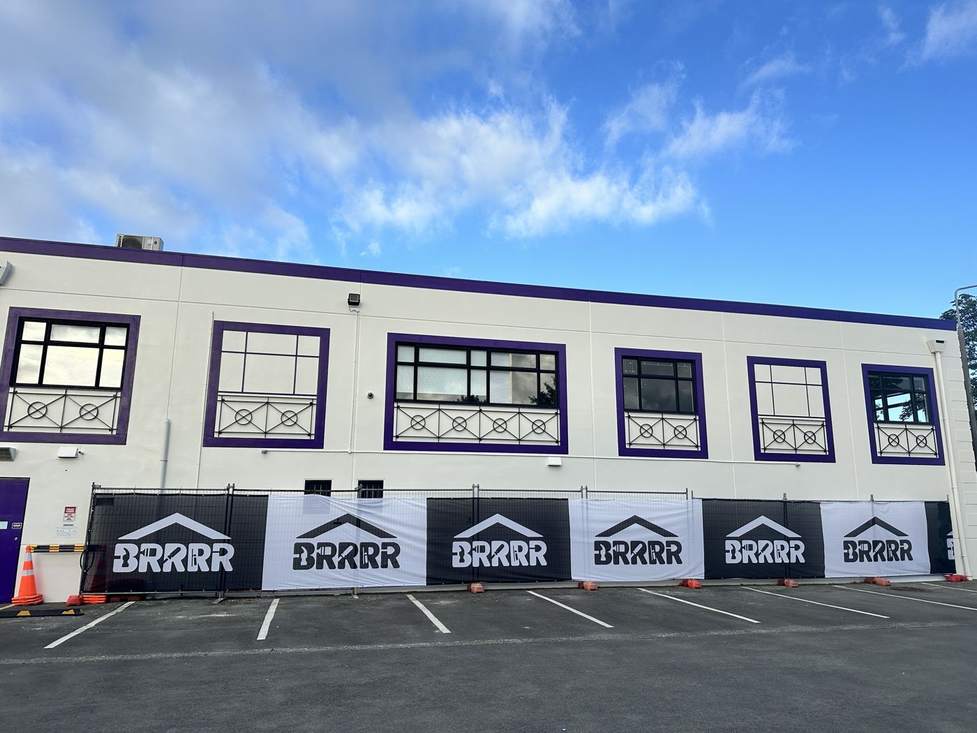 Repaired and repainted building with BRRRR site fencing banners